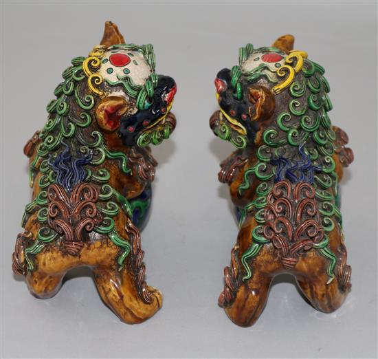A pair of Chinese polychrome pottery figures of lion-dogs with balls, height 12cm